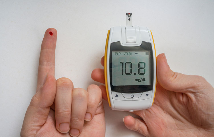 Diabetic patient is using glucometer to check glucose level