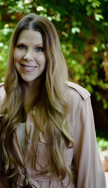 Dawn Dunsmore standing against a green foliage background