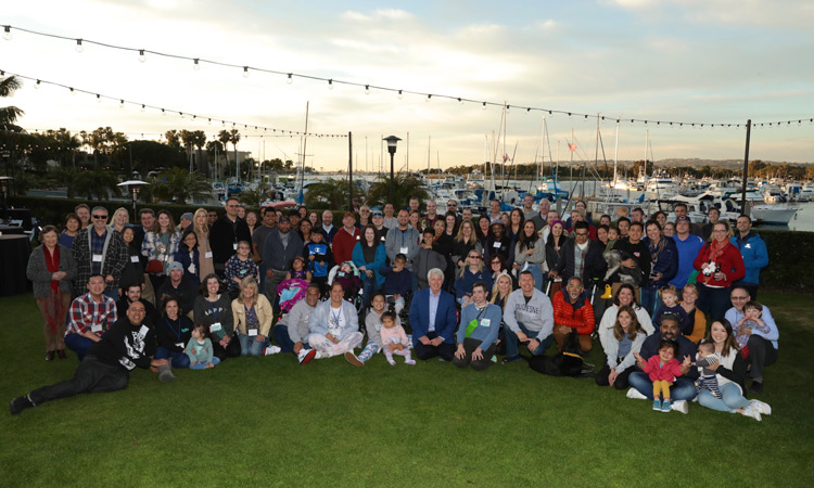 Large group of people gathered in front of marina at Sunset