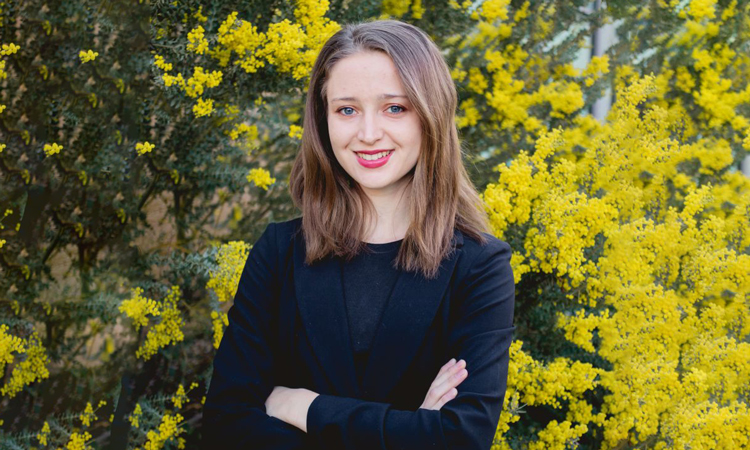 Katya Marchetti, a young woman with brown hair against a background of yellow flowers