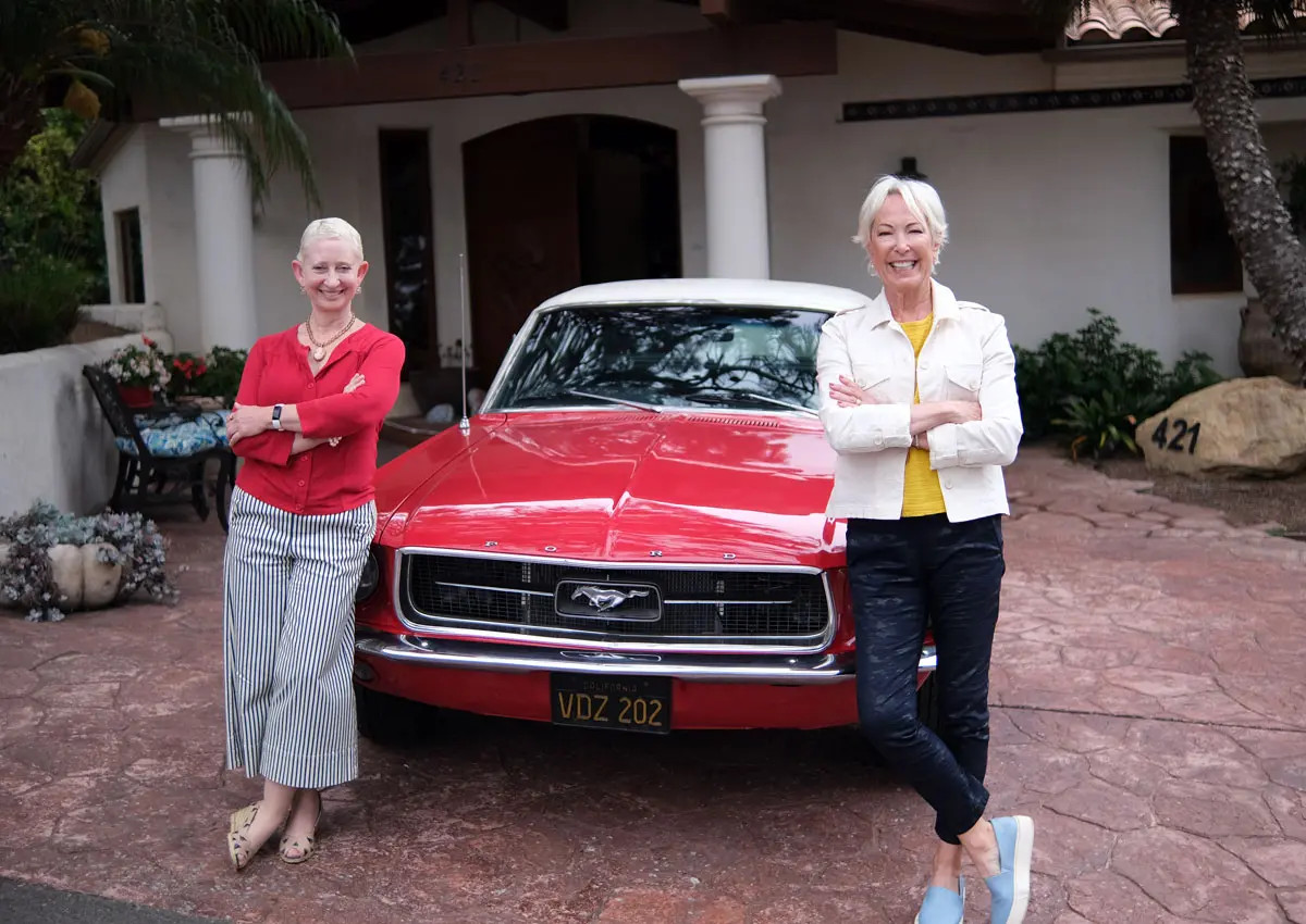 Helen Eckmann and Ruth Claire Black stand by a Ford Mustang in a driveway