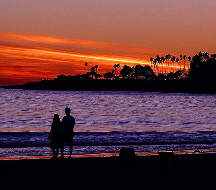 Photo of a sunset over the ocean at the beach.