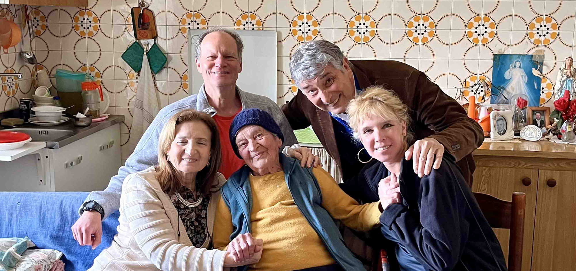 A group of people gather around an elderly woman