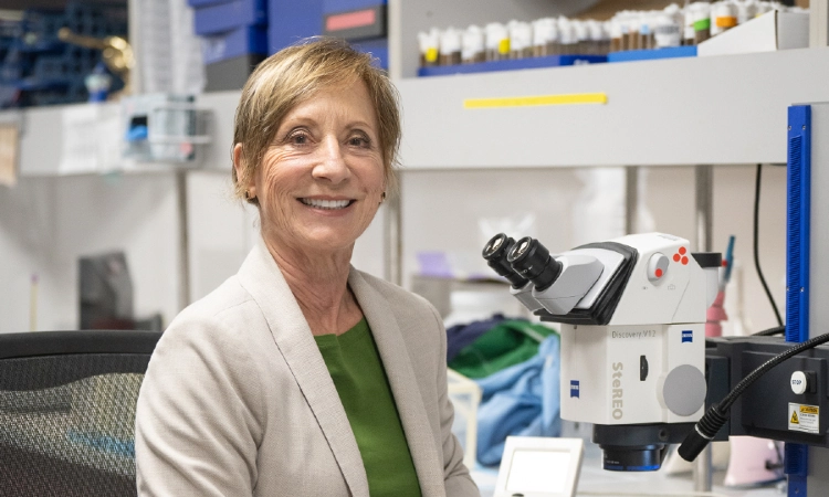 Karen Ocorr, PhD, at microscope facing camera