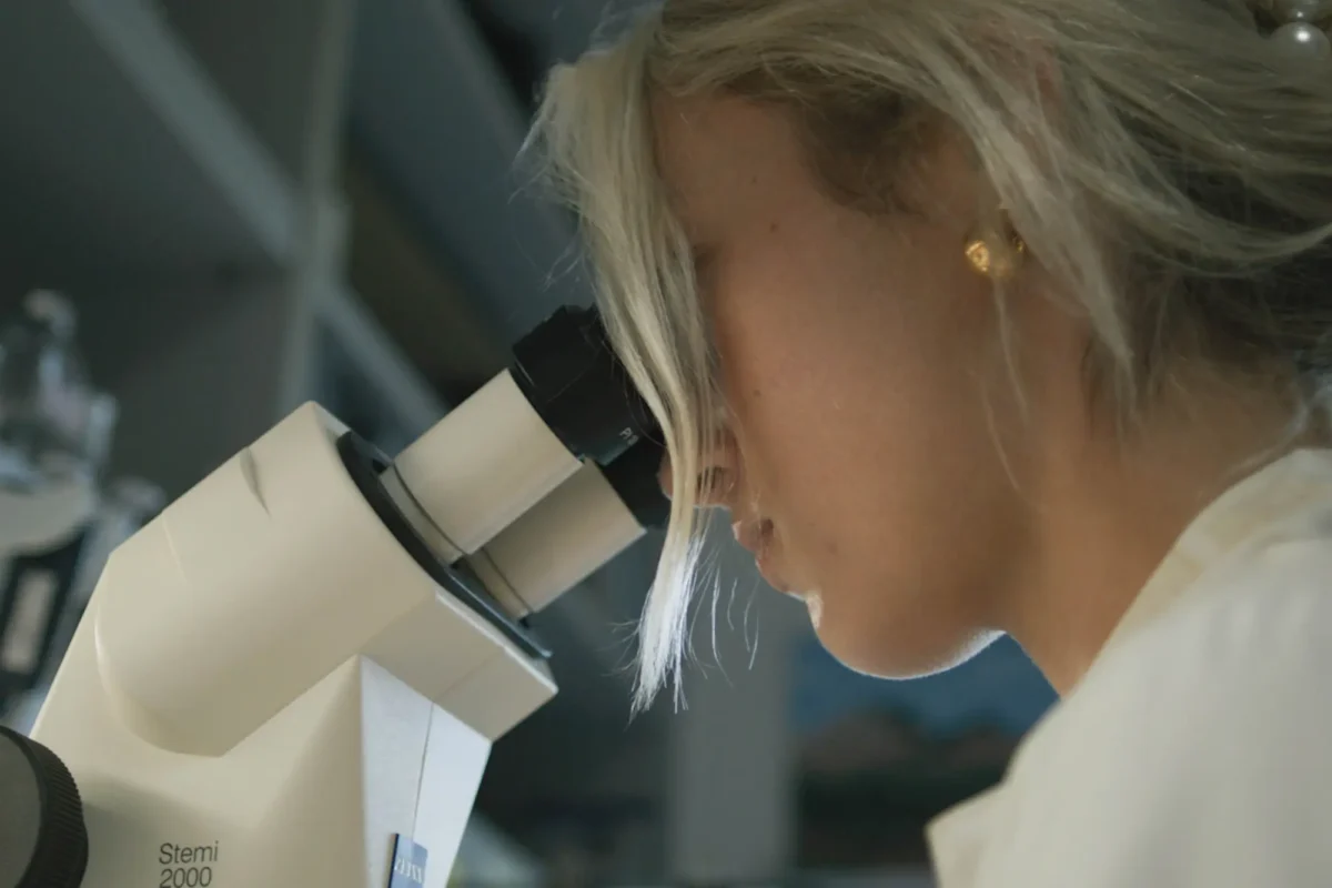 Scientist looking into a microscrope