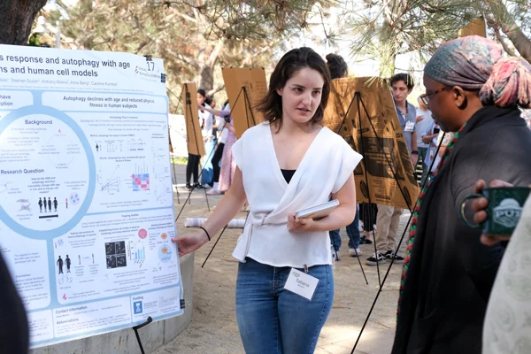 Tatiana Moreno presenting her post to Soda Diop with other poster presentations in the background